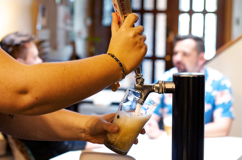 Pouring a beer from the tap at THE coLABorative