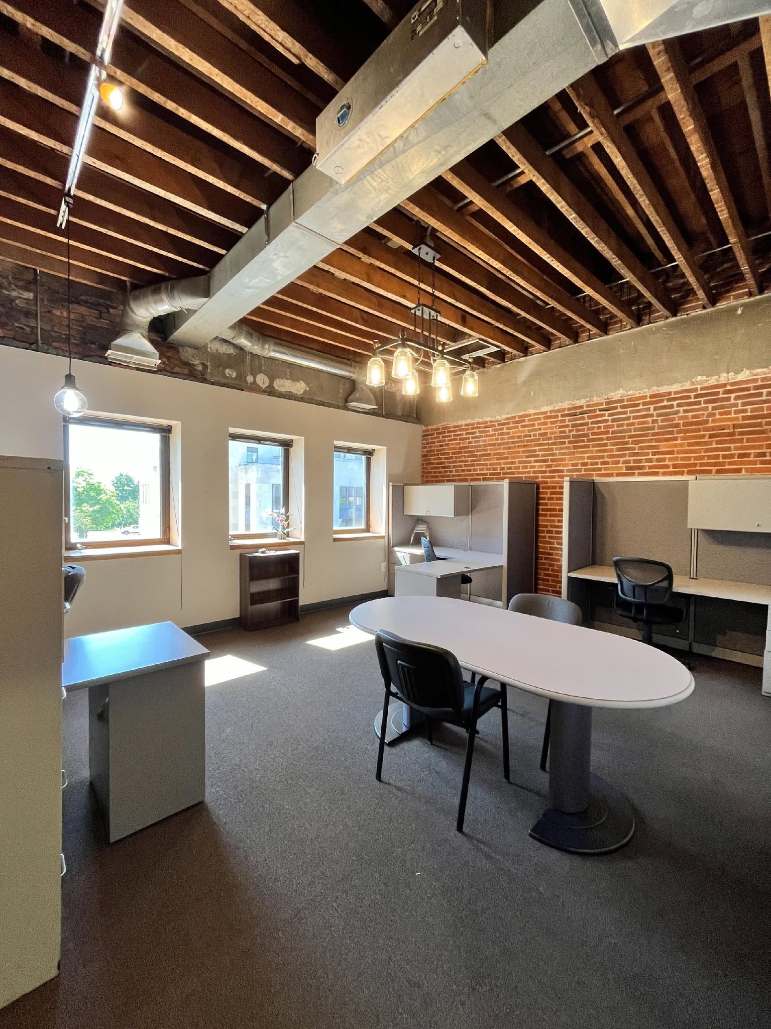 Premium private office with exposed beam ceiling and brick