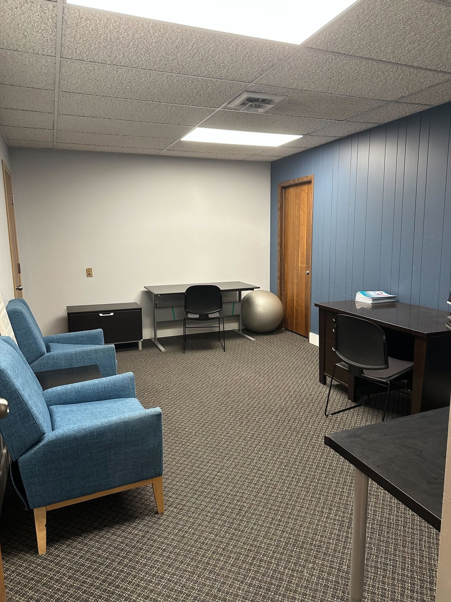 Private office with blue accent wall and comfortable seating